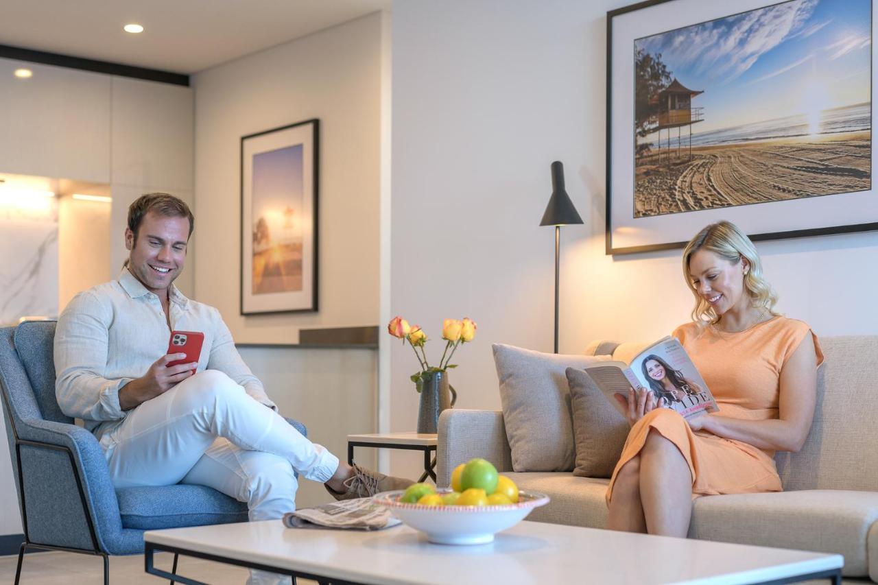 Meriton Suites Surfers Paradise โกลด์โคสต์ ภายนอก รูปภาพ A couple reading a magazine in their living room